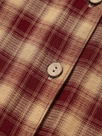 Gros plan sur les détails boutonnés de la robe chemise à carreaux - vue frontale montrant les boutons décoratifs et fonctionnels sur toute la longueur, signature du style Black-Coat
