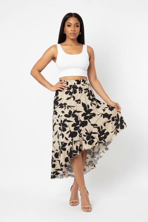 Jupe asymétrique florale Silhouette-Chic à imprimé floral avec ourlet à volants - vue corps entier d'une mannequin avec main sur la hanche en pose confiante sur fond blanc studio, illustrant la silhouette romantique et féminine, la longueur midi flatteuse, l'ourlet asymétrique à volants unique et l'attitude audacieuse et élégante que procûre cette jupe