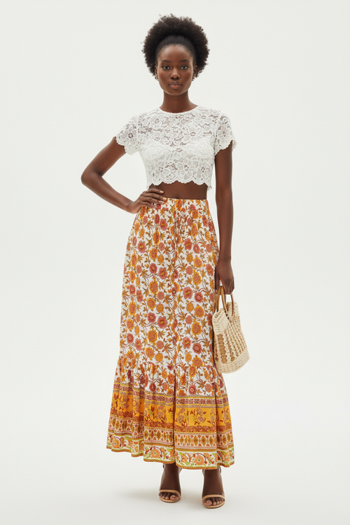 Jupe longue bohème Silhouette-Chic orange et crème avec imprimé floral, bordure décorative et fente latérale - vue de face frontale complète d'une mannequin en pose debout sur fond blanc studio, présentant la taille élastique confortable, l'imprimé floral bohème orange et crème sophistiqué, la bordure décorative unique en bas, la fente latérale audacieuse et la longueur maxi fluide