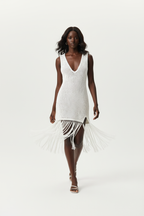 Robe cover-up crochet ajouré blanc sans manches avec fente latérale et franges - vue de face complète montrant la silhouette mini estivale, le motif openwork artisanal en coton 100% qui crée un jeu de transparence sophistiqué, et la coupe fluide qui sublime la silhouette féminine - Mannequin en mouvement dynamique sur fond blanc studio - Collection mode féminine accessible premium Black-Coat