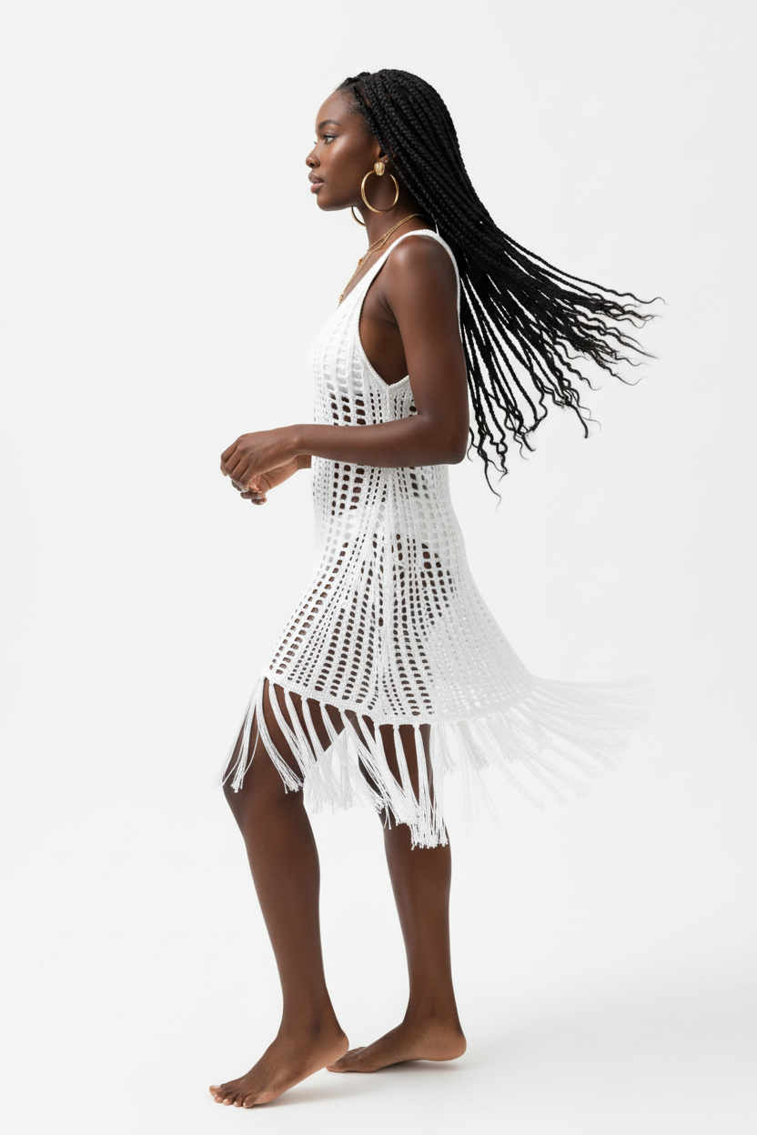 Robe cover-up crochet blanc en mouvement gracieux - vue de profil latéral montrant la fluidité du coton ajouré, la fente latérale sensuelle qui révèle la jambe, les détails franges bohèmes en bas de robe, et la silhouette élégante sans manches - Style éditorial bohème accessible - Vêtements élégants à prix doux Black-Coat