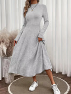Robe midi femme silhouette A-line en tricot côtelé, texture nervurée verticale, coupe évasée trapèze, longueur midi, mélange coton polyester, corsage ajusté avec jupe évasée, vue de face montrant la texture côtelée et la forme A-line flatteuse
