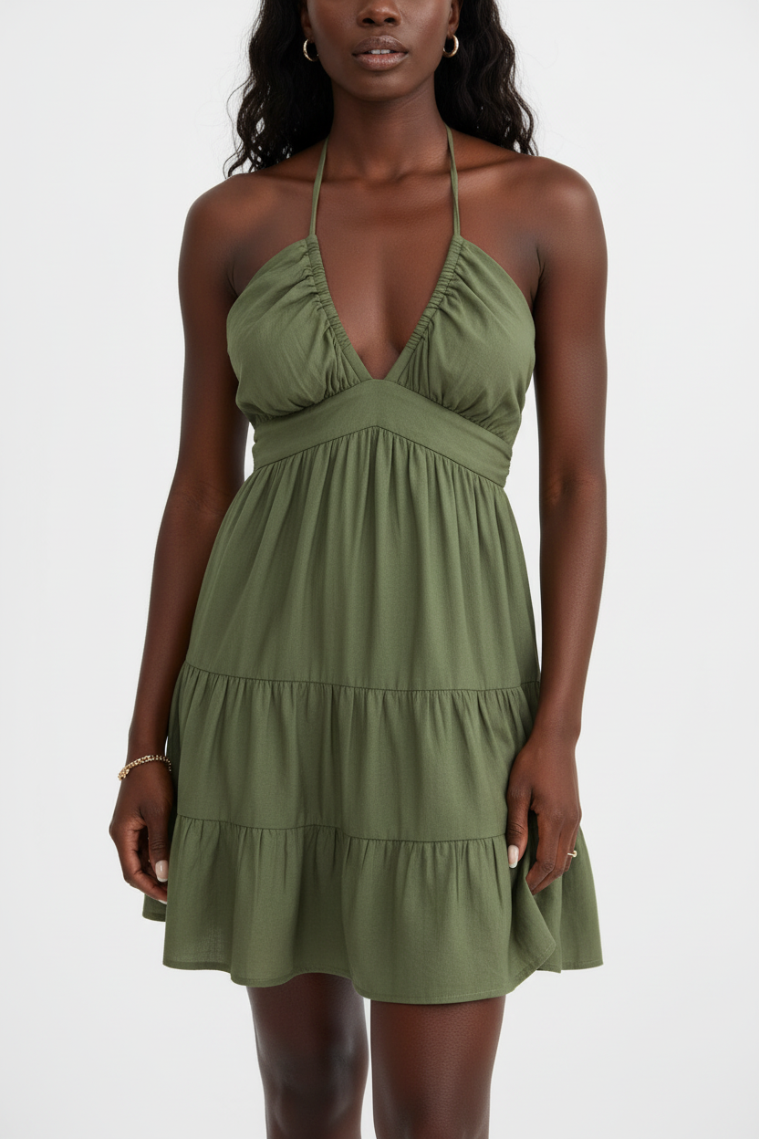 Robe mini halter smockée kaki olive avec col V profond à fronces empire, dos smocké ajustable avec laçage halter et trois niveaux de volants étagés - vue de face complète sur fond blanc studio montrant la silhouette romantique et féminine, le tissu 100% polyester léger en kaki olive naturel et sophistiqué - Mannequin en pose estivale élégante - Collection mode féminine accessible premium Black-Coat