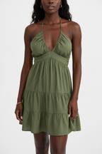 Robe mini halter smockée kaki olive avec col V profond à fronces empire, dos smocké ajustable avec laçage halter et trois niveaux de volants étagés - vue de face complète sur fond blanc studio montrant la silhouette romantique et féminine, le tissu 100% polyester léger en kaki olive naturel et sophistiqué - Mannequin en pose estivale élégante - Collection mode féminine accessible premium Black-Coat