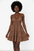 Robe mini halter smockée marron mocha avec col V profond à fronces empire, dos smocké ajustable avec laçage halter et trois niveaux de volants étagés - vue de face complète sur fond blanc studio montrant la silhouette romantique et féminine, le tissu 100% polyester léger en marron mocha chaud et enveloppant - Mannequin en pose estivale élégante - Collection mode féminine accessible premium Black-Coat