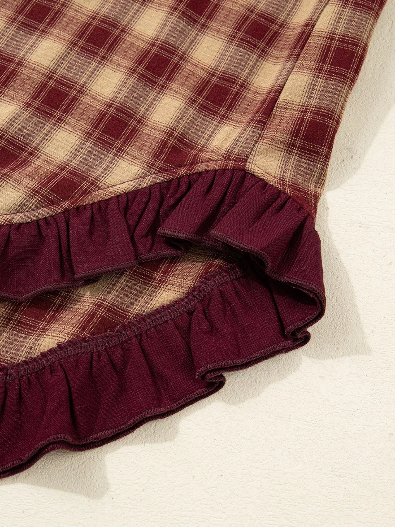 Détail de l'ourlet patchwork à volants de la robe chemise Black-Coat - vue rapprochée révélant la finition sophistiquée et le travail de couture premium de cette collection accessible
