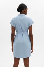 Vue arrière de la robe chemise mini boutonnée col chemisier en bleu ciel sur fond blanc studio - dos révélant le nœud de la ceinture nouée sculpturale dans le dos et la longueur mini élégante - Détail du design chic et professionnel - Style premium Black-Coat