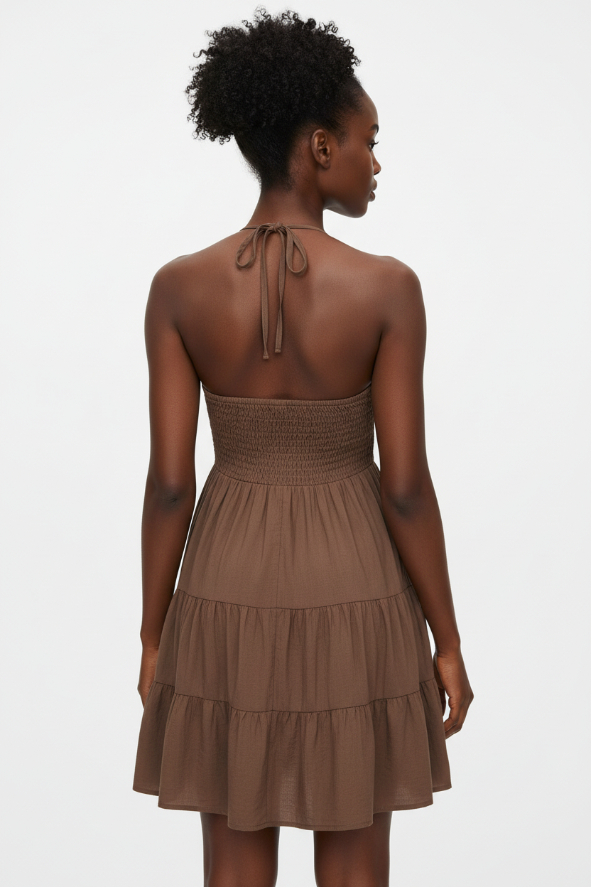 Vue arrière de la robe mini halter smockée marron mocha sur fond blanc studio - dos révélant le smocké ajustable sophistiqué, le laçage halter élégant dans la nuque, et les trois niveaux de volants étagés en marron mocha chaleureux - Détail du design romantique et enveloppant - Style premium Black-Coat