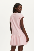 Vue arrière de la robe t-shirt mini col rond à manches cap en rose blush sur fond blanc studio - dos révélant le volant bas romantique et la coupe décontractée de la robe mini - Détail du design casual chic - Style premium Black-Coat