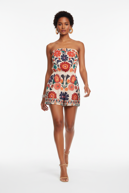  Combinaison Bustier Florale Bohème – L'Art de Vivre en Couleurs
Alt : Mannequin portant une combinaison bustier courte crème à imprimé floral bohème multicolore — grandes fleurs rouges, oranges, bleues et vertes avec bordure ethnique en bas, haut bandeau élastique, taille cintrée, short intégré, en marche sur fond blanc. Tenue estivale festive et féminine idéale pour festival, soirée ou escapade.