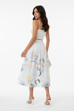 Jupe midi imprimé floral blanc boutonnée - vue arrière trois-quarts avec mannequin regardant par-dessus l'épaule montrant taille élastique tissu floral fluide et drapé élégant de la jupe midi - BLACK-COAT