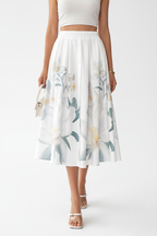 Jupe midi imprimé floral blanc boutonnée - gros plan du bas de jupe des cuisses aux mollets montrant motif floral délicat aux couleurs pastel douces et feuilles vertes en mouvement avec tissu polyester fluide et longueur midi élégante - BLACK-COAT