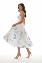 Jupe midi imprimé floral blanc boutonnée - vue de profil opposé avec bras légèrement étendus montrant silhouette complète motif floral et longueur midi élégante - BLACK-COAT