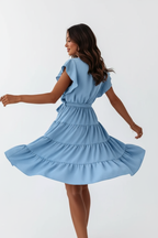 Robe mini étagée manches volantées bleu clair avec ceinture à nouer - mannequin tournoyant en mouvement montrant la jupe étagée s'évasant magnifiquement, volants créant mouvement dynamique romantique, manches volantées, ceinture à la taille, effet tourbillon gracieux féminin - BLACK-COAT
