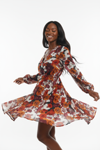 Mannequin en pirouette joyeuse portant la robe florale bohème manches bouffantes Black-Coat, vue trois-quarts dynamique — jupe évasée s'ouvrant en corolle dans le mouvement capturant la légèreté absolue du tissu fleuri, imprimé floral grand format tourbillonnant avec grâce, manches bouffantes longues s'animant librement, énergie romantique et joyeuse rayonnante, taille élastique cinéant la silhouette, fond blanc épuré, photographie mode éditoriale bohème chic Black-Coat

