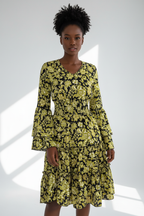  Mannequin portant la Robe Imprimé Floral Smockée Volants Black-Coat vert jaune et noir - vue de face montrant le décolleté en V et la taille smockée