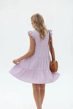 "Robe à volants étagés lilas avec manches papillon - vue arrière trois-quarts en marche montrant les détails du dos et le flux des volants - BLACK-COAT"