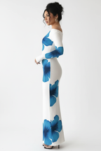 "Robe maxi blanche imprimé floral bleu épaule asymétrique - vue de profil latéral montrant la silhouette moulante bodycon ajustée, décolleté asymétrique visible de côté, imprimé floral bleu audacieux, ourlet maxi, fond blanc studio BLACK-COAT"