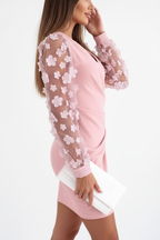 "Robe mini moulante rose manches mesh appliqués floraux - vue de profil latéral montrant la silhouette ajustée bodycon, manches transparentes mesh avec fleurs 3D visibles de côté, corsage froncé, tissu rose poudré, fond blanc studio BLACK-COAT"